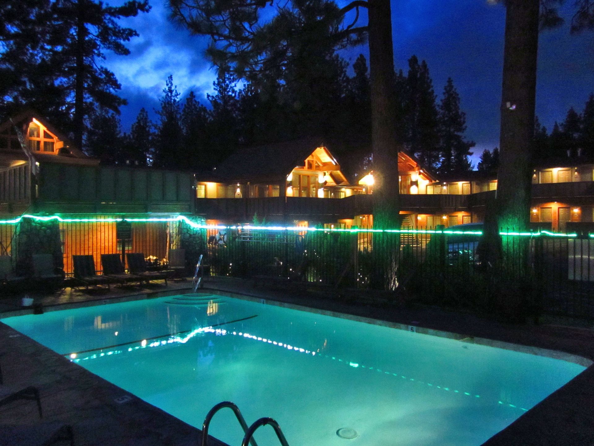 A large swimming pool is lit up at night