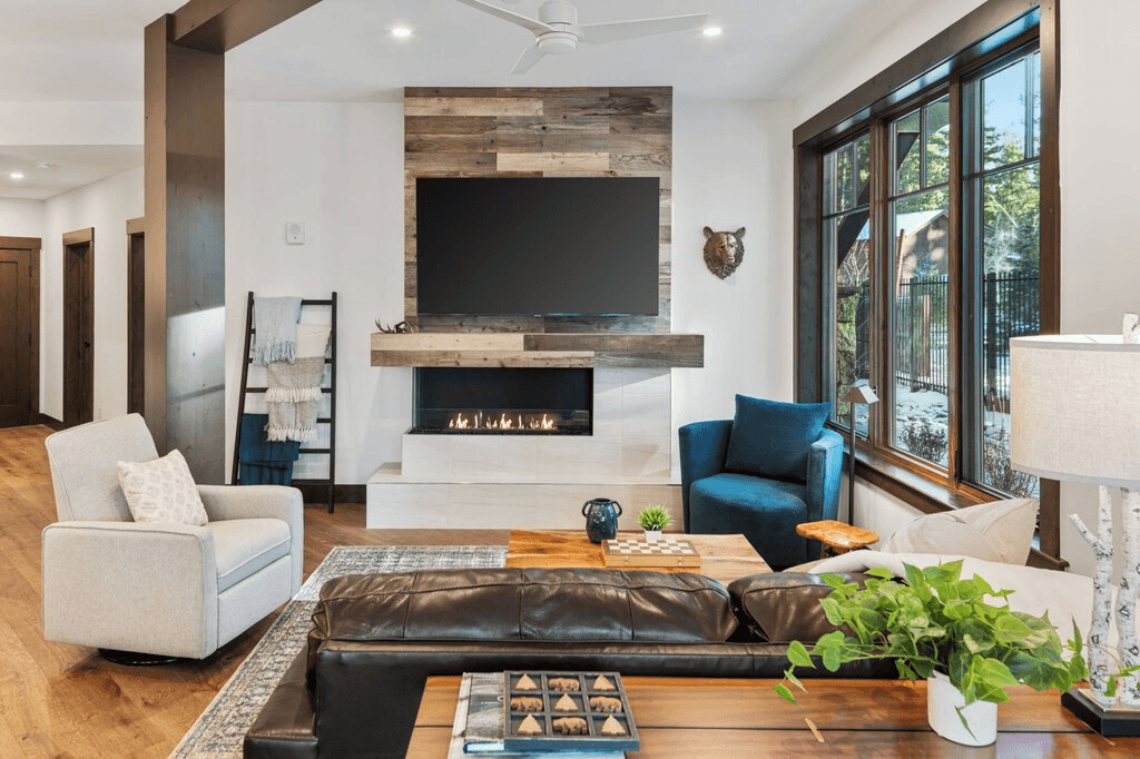 A living room with a couch , chairs , a fireplace and a flat screen tv.