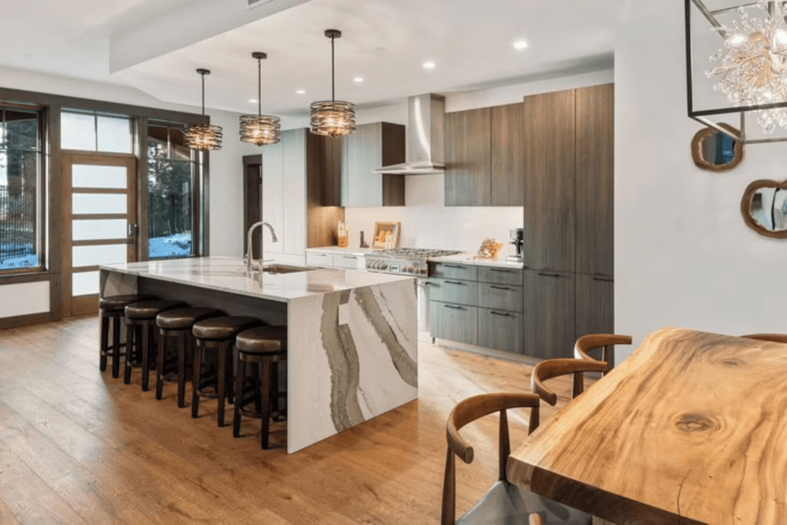 A kitchen with a large island and a wooden table.