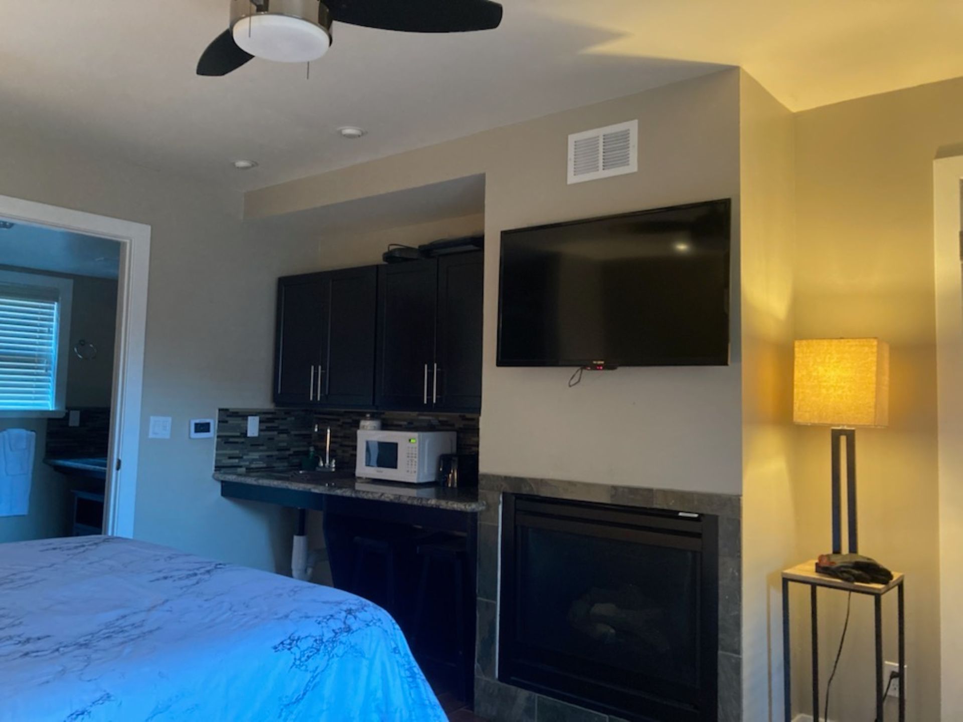 A bedroom with a fireplace and a flat screen tv