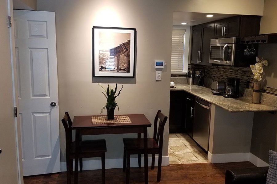 A kitchen with a table and chairs and a picture on the wall.