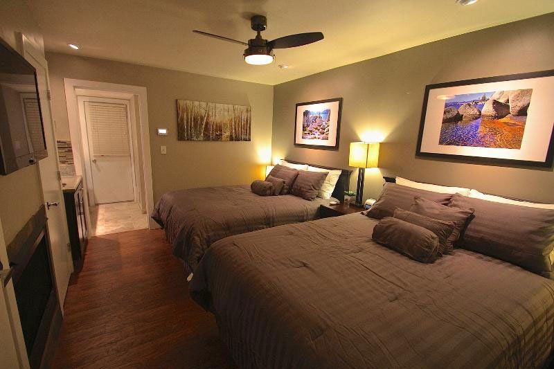 A hotel room with two beds and a ceiling fan
