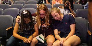 3 FCA athletes sitting in chapel listing to God's word