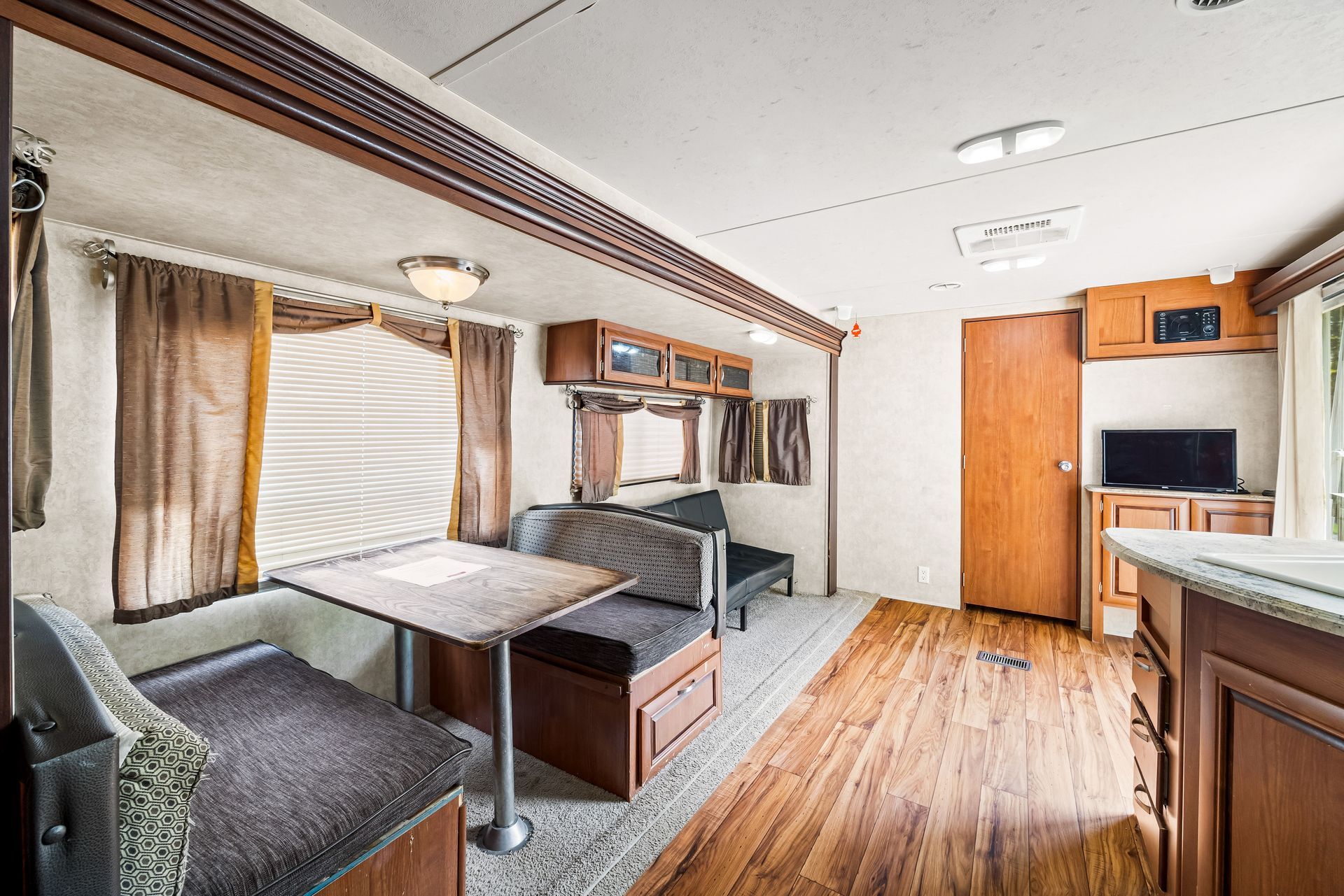 A living room in a trailer with a table and couch.