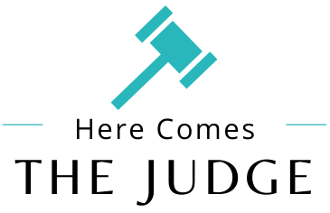A logo for here comes the judge with a blue gavel