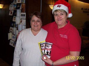 Two women are posing for a picture and one is wearing a santa hat