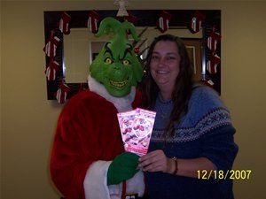 A woman is posing for a picture with a grinch costume