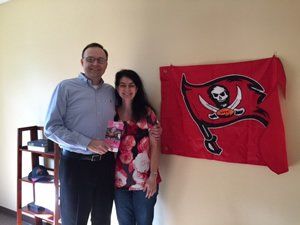 A man and a woman standing in front of a tampa bay flag