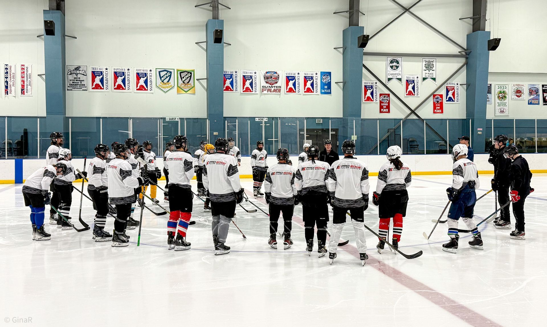 Youth hockey team gathered on an indoor ice rink for a group huddle before practice or a game