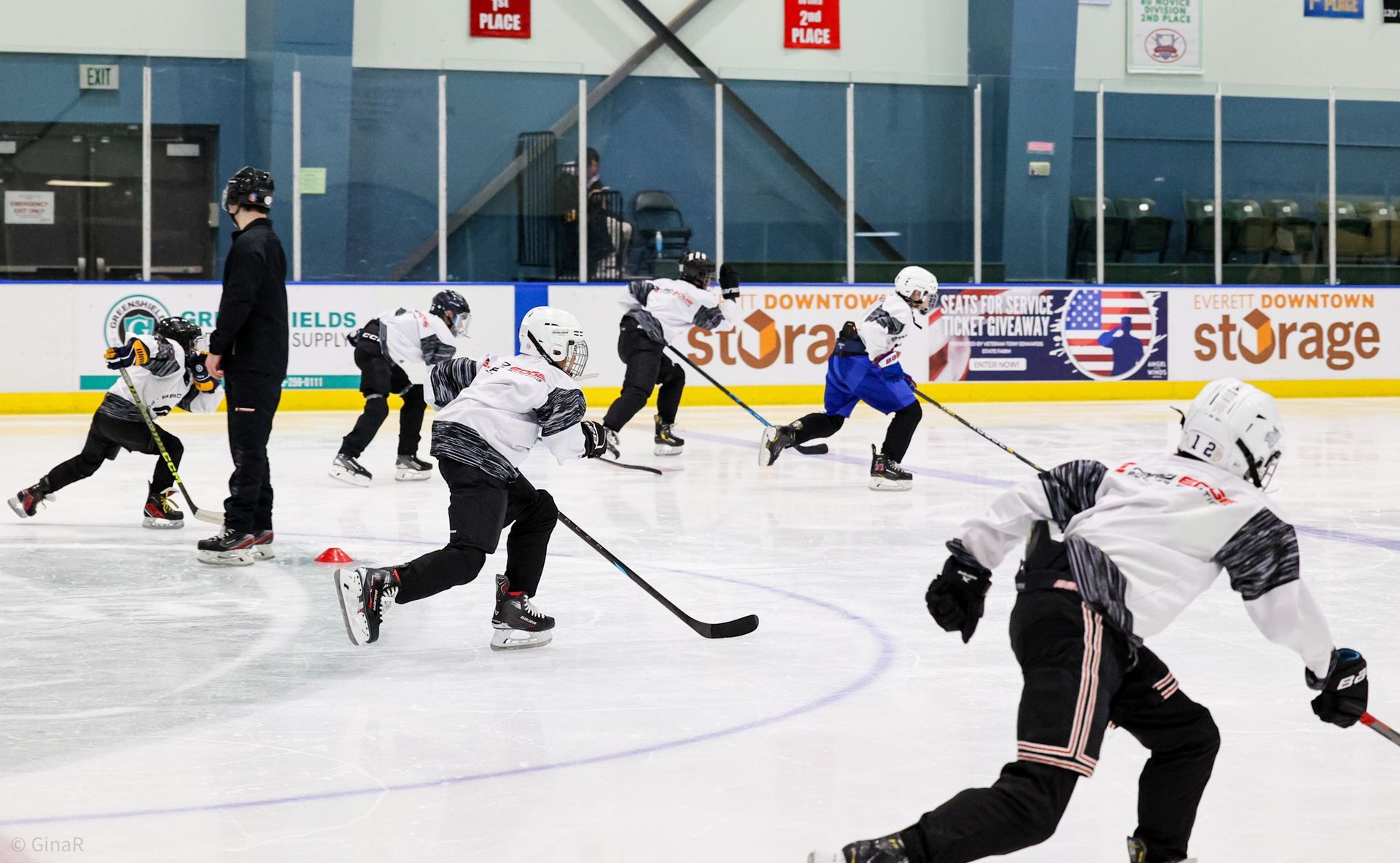 Ice hockey game with players in white and black jerseys skating on an indoor rink