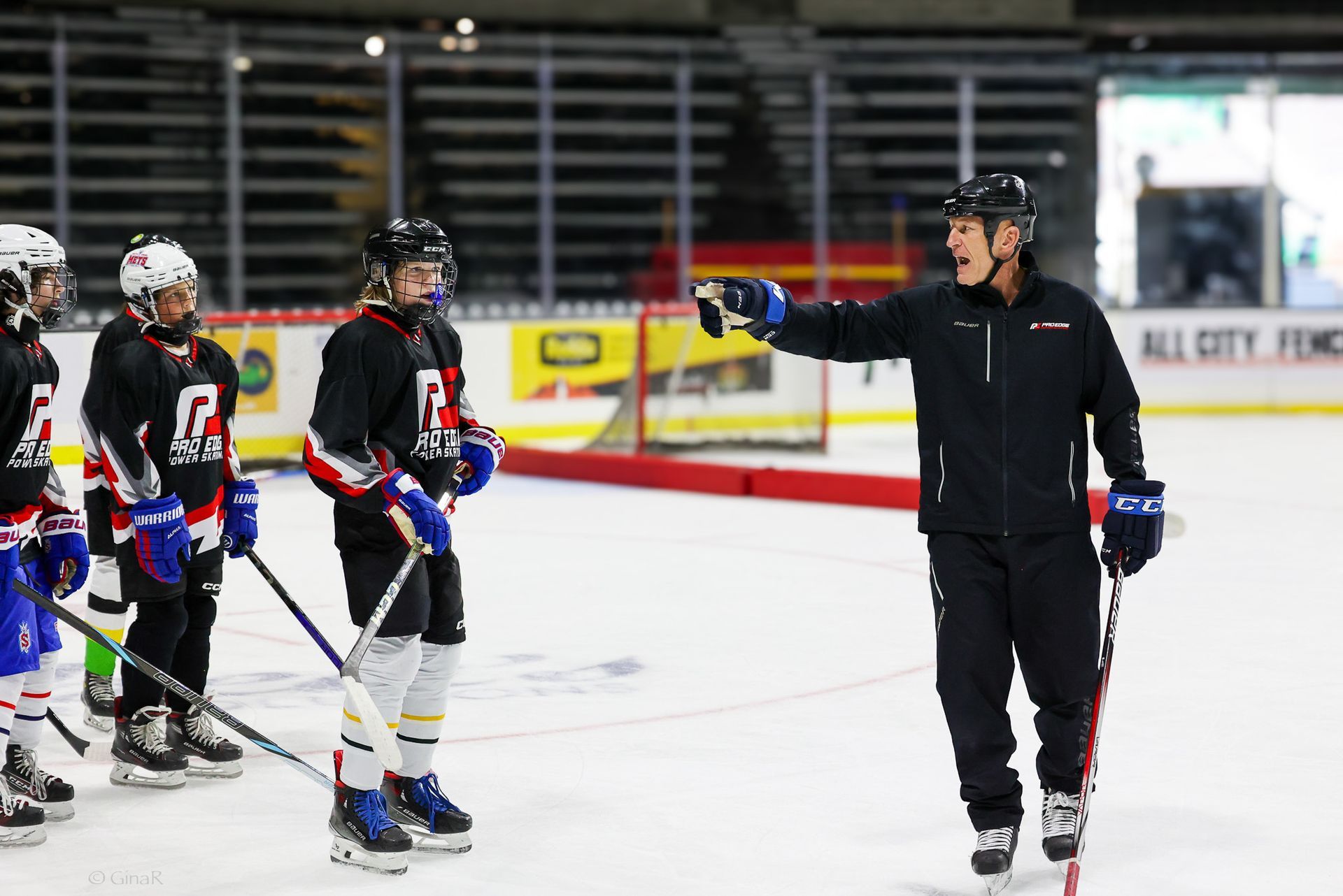 Ice hockey coach pointing at players during practice on an indoor rink