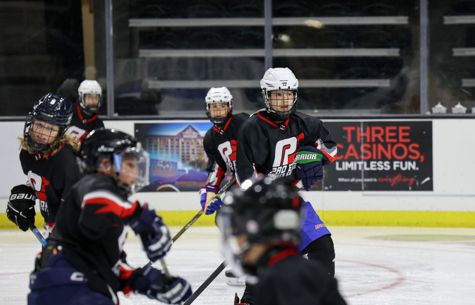 Ice hockey players in black and white uniforms compete on the rink during a fast play.