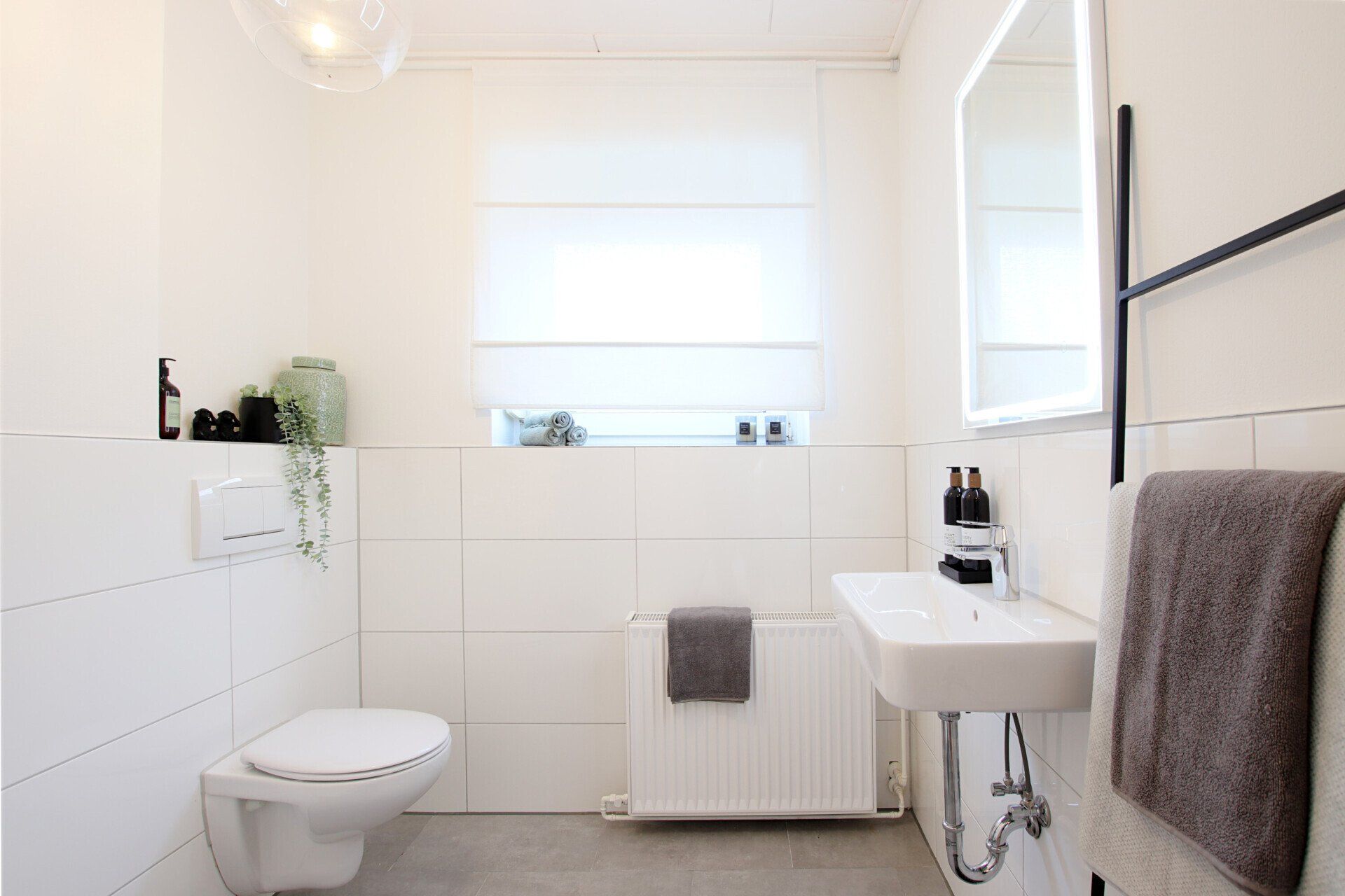 Ein Badezimmer mit Toilette, Waschbecken und Spiegel.