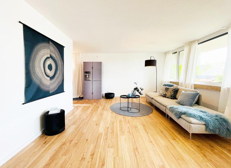 Ein Wohnzimmer mit Couch, Tisch und Kühlschrank.
