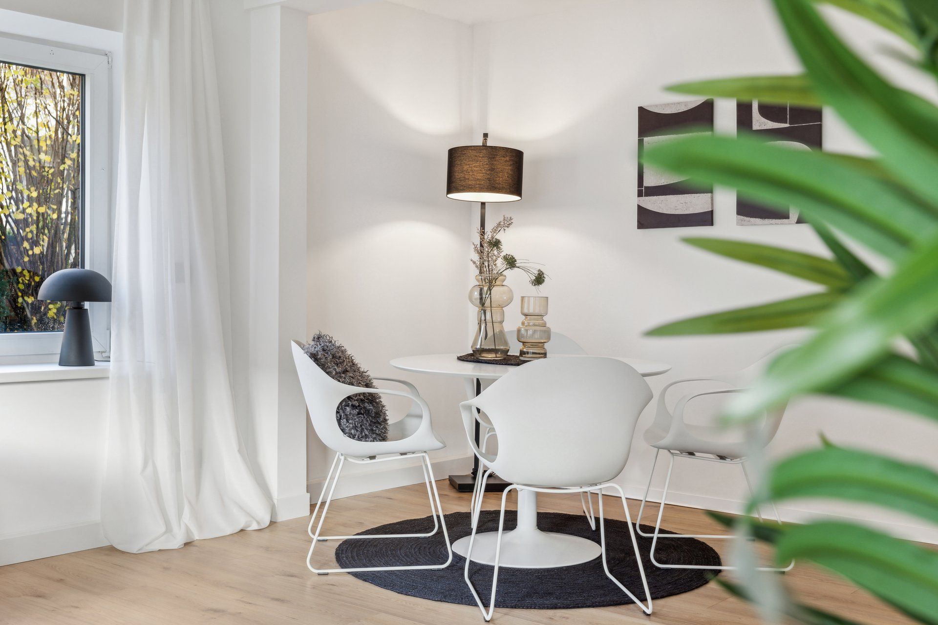 Ein Wohnzimmer mit einem Tisch und Stühlen und einer Lampe