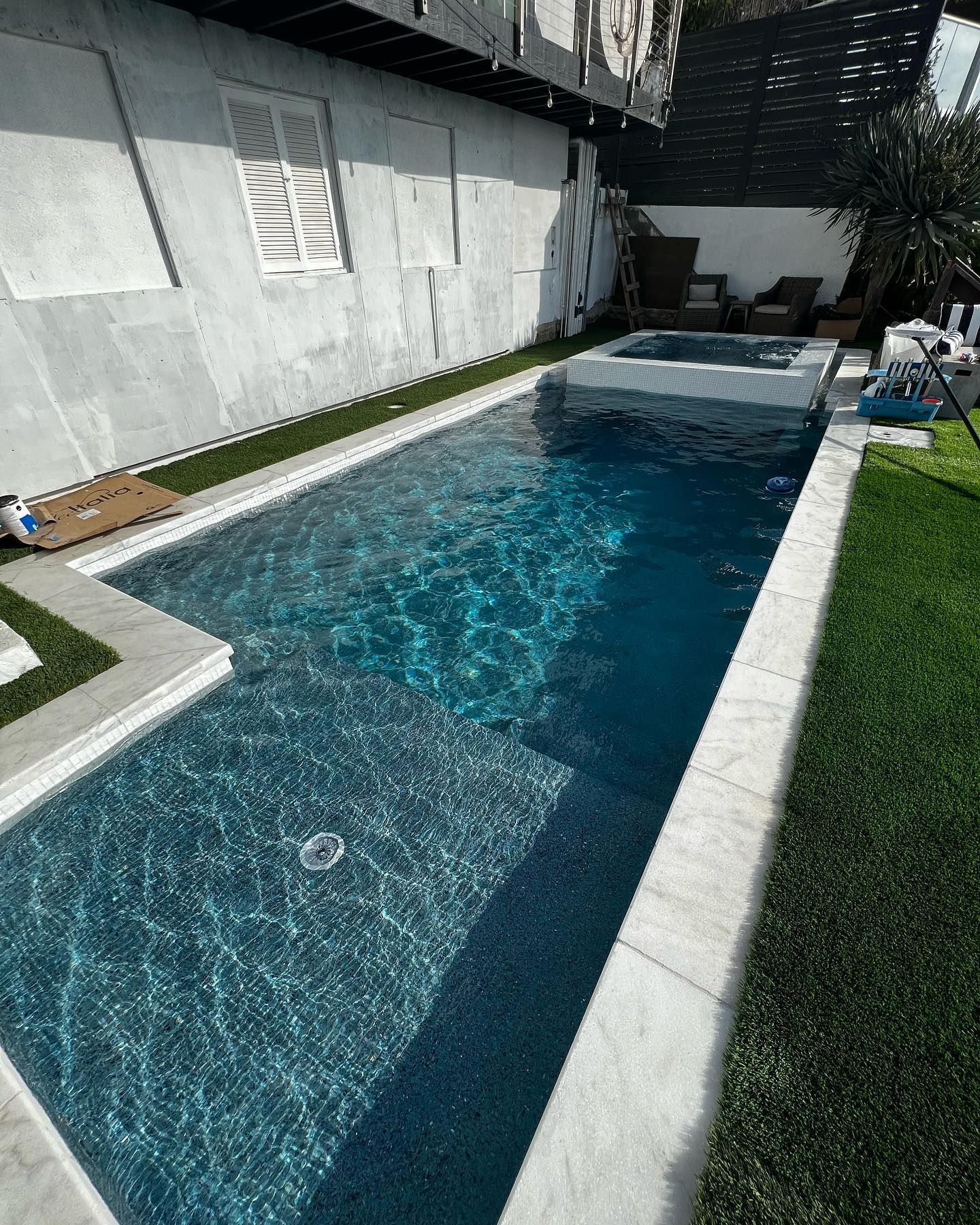 A large swimming pool in the backyard of a house.
