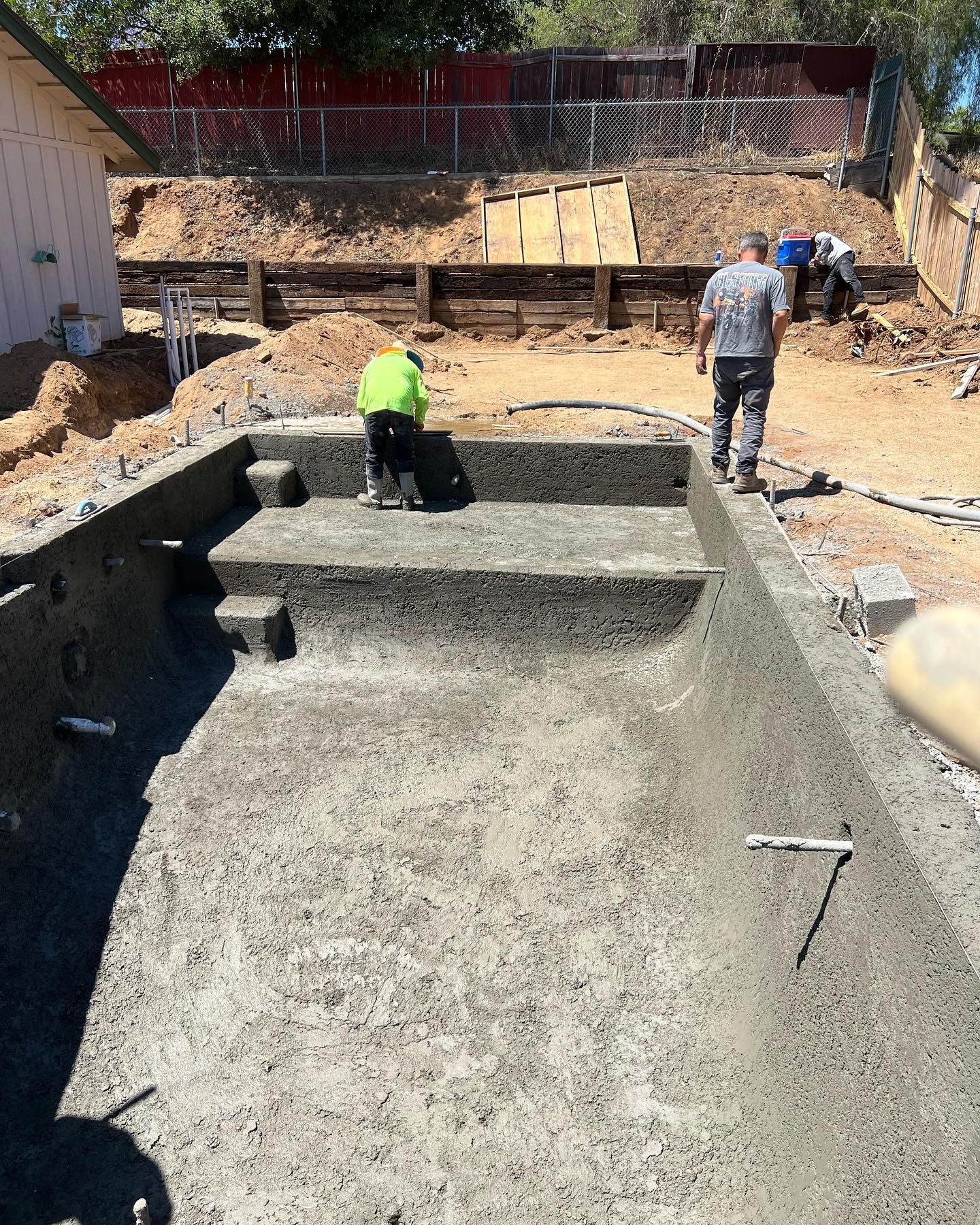 A group of men are working on a swimming pool.