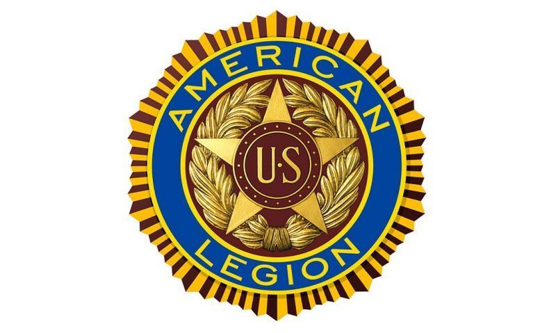 American Legion circular emblem with gold laurel, blue ring, and red center with “US” initials