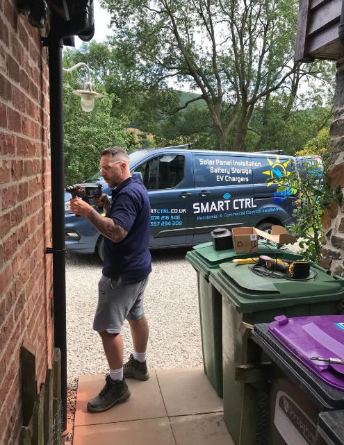 Man working on building exterior, van labeled