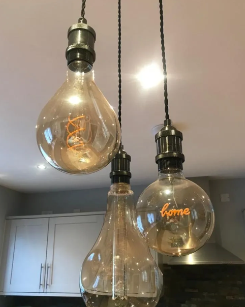 Three pendant lights with large, teardrop-shaped bulbs hang from the ceiling. One bulb has