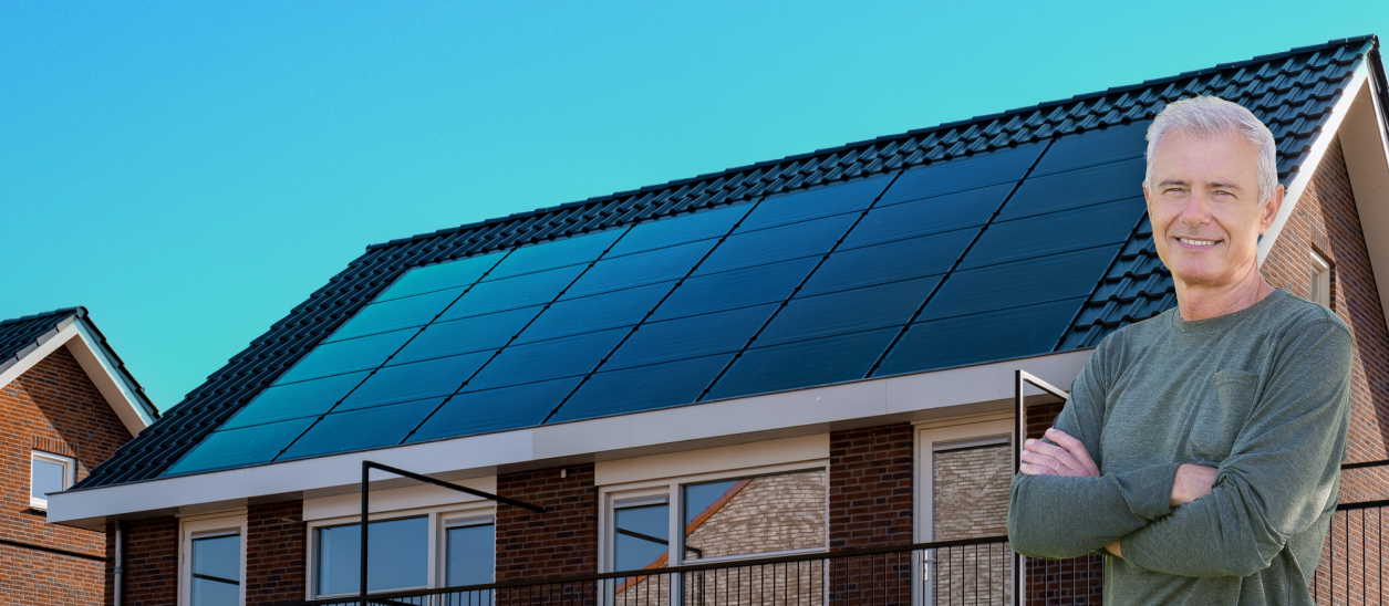 A man is standing in front of a house with solar panels on the roof.