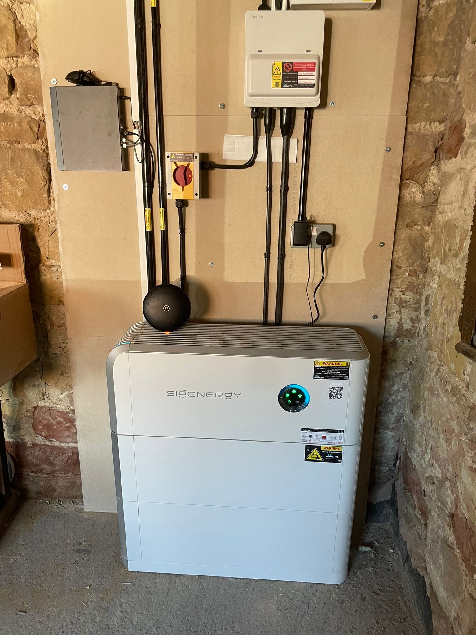 Solar battery unit with electrical components mounted on wall.