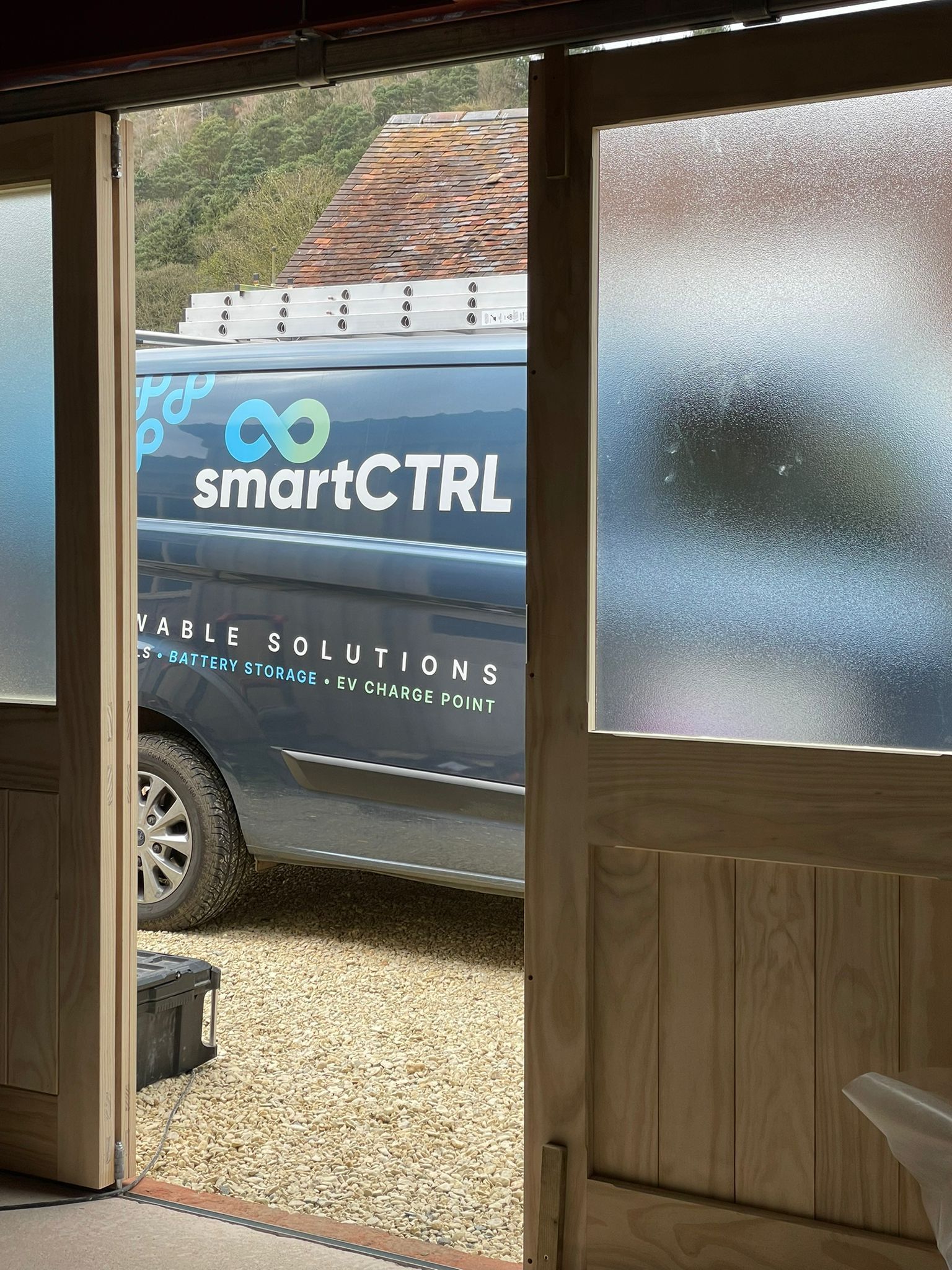 Open wooden doors with a partially visible van labeled