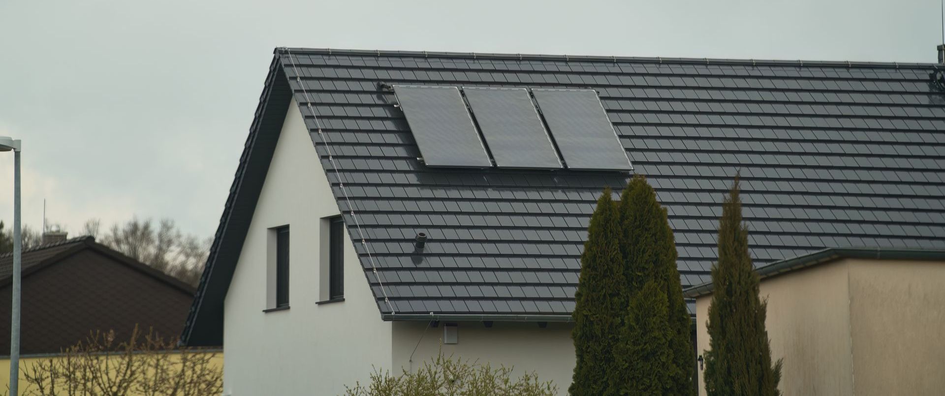 House with solar panels on the roof and two windows.
