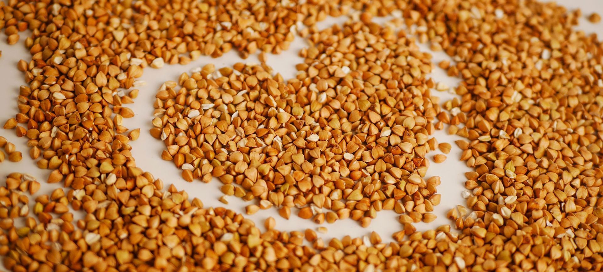 Buckwheat Health Benefits. A pile of buckwheat grains on a white surface in the shape of a heart. Discover the Nutritional Benefits of Buckwheat: A Gluten-Free Superfood for Your Kitchen