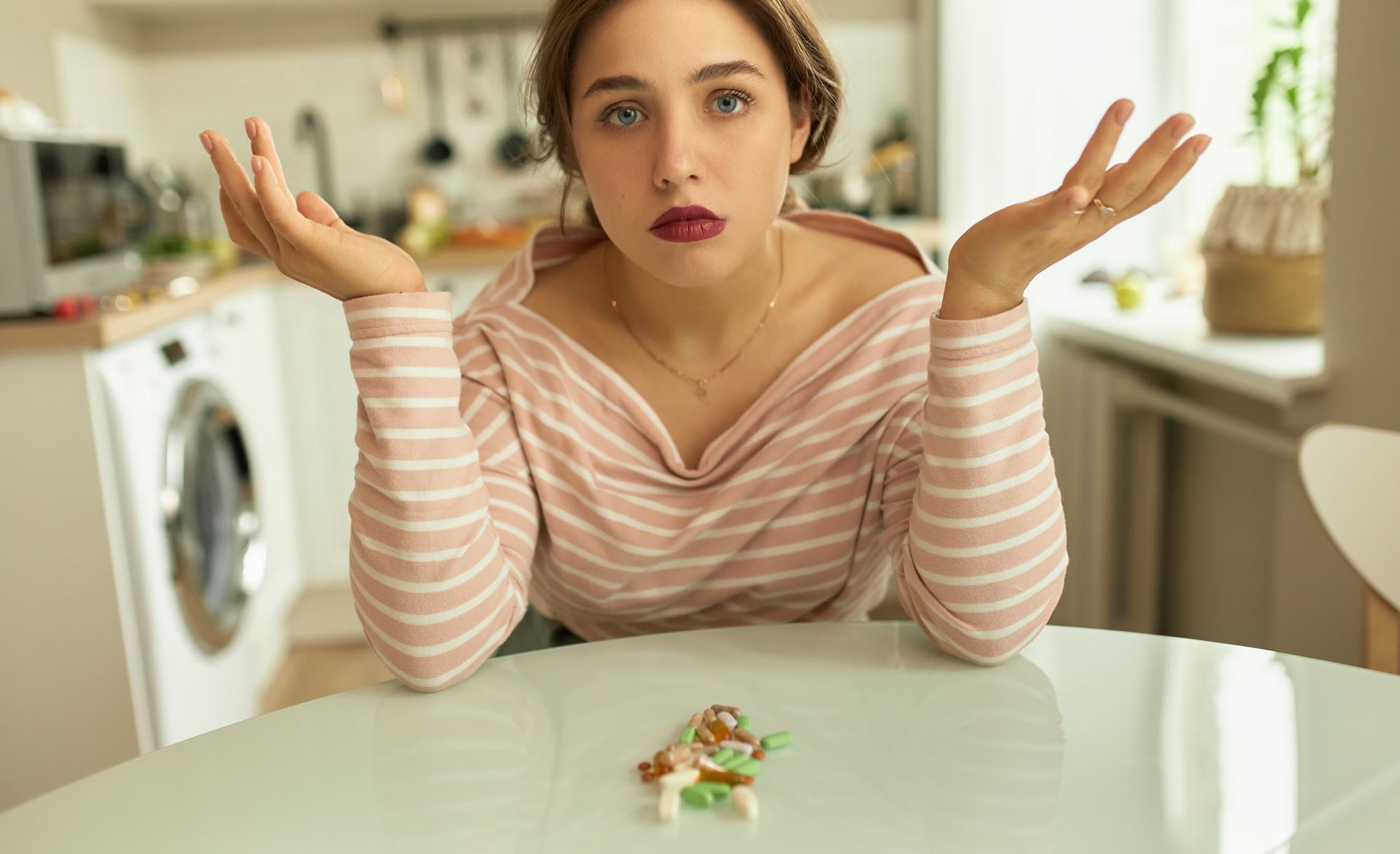 A woman is sitting at a table with a plate of food on it. How to Create a Supplement Strategy for Better Health