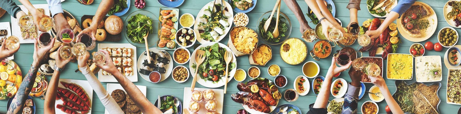 A group of people is sitting at a table with plates of food, discussing Nutritional Therapy