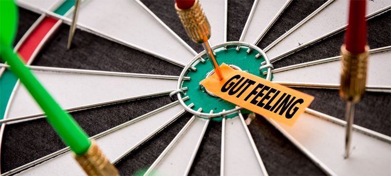 Dartboard with darts around a target labeled