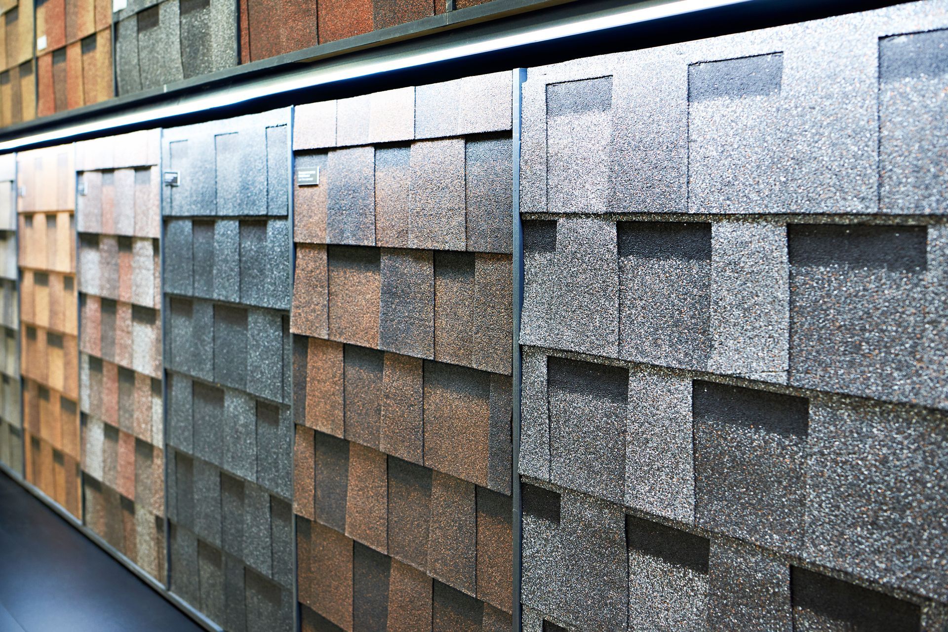 Roofing materials display featuring asphalt shingles in multiple colors and styles