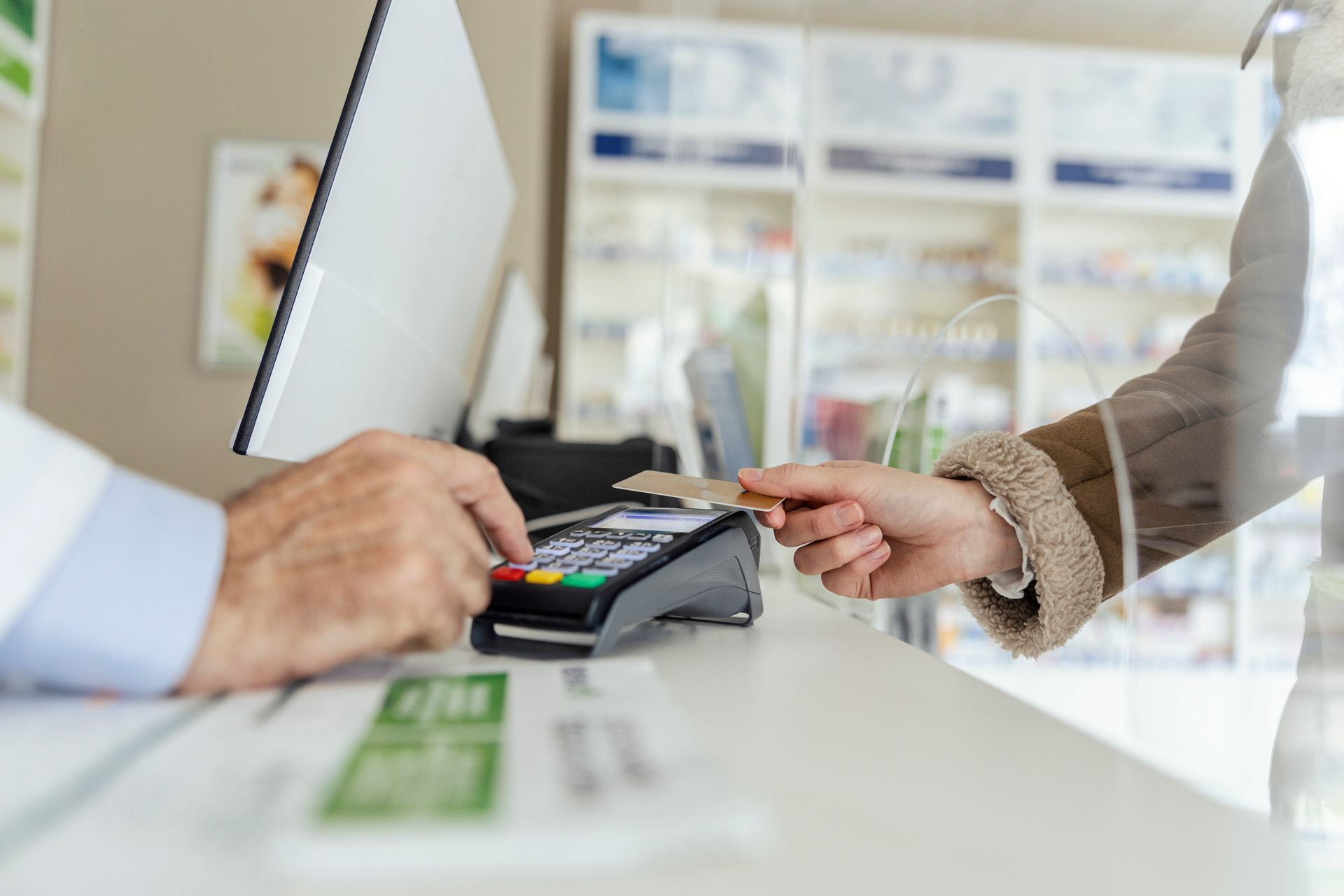 Customer tapping card on a payment terminal at a checkout counter