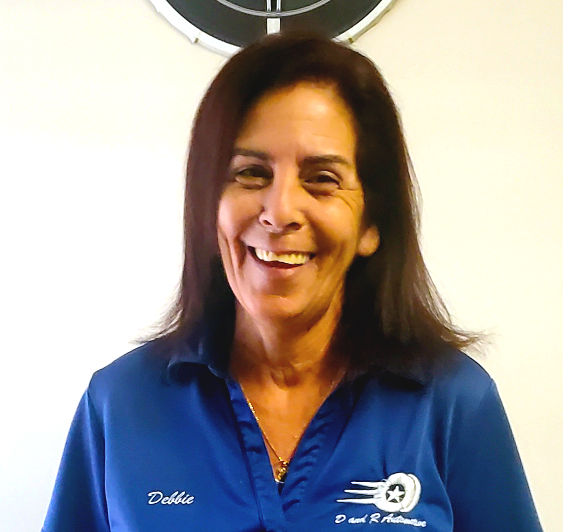Smiling woman in a blue polo shirt against a light background