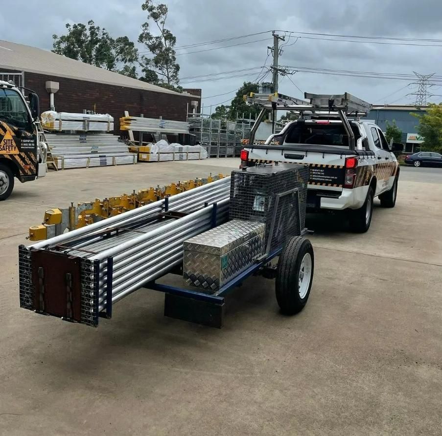 A Truck Is Pulling a Cart with Scaffolding on It — Site Safety NSW in Sandgate, NSW