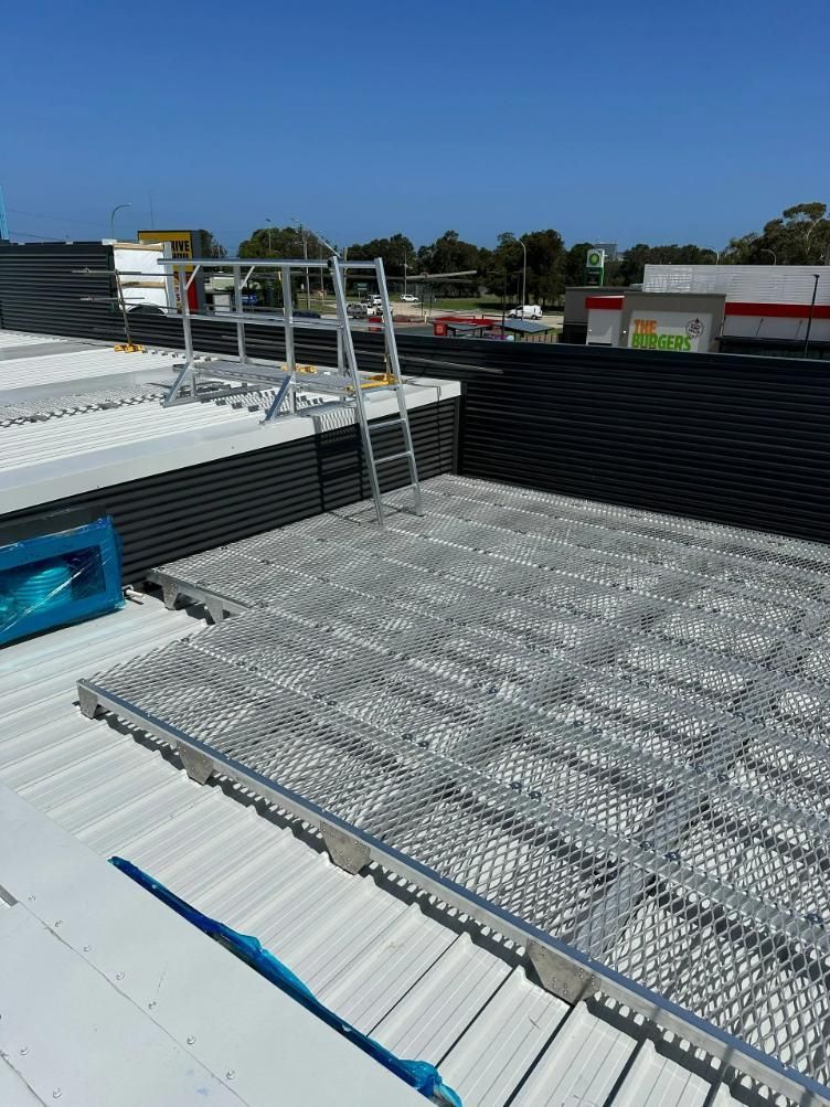 A Ladder Is Sitting on Top of A Metal Roof — Site Safety NSW in Sandgate, NSW