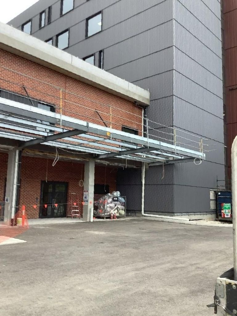 A Large Building with A Lot of Windows and A Canopy Over the Entrance — Site Safety NSW in Sandgate, NSW