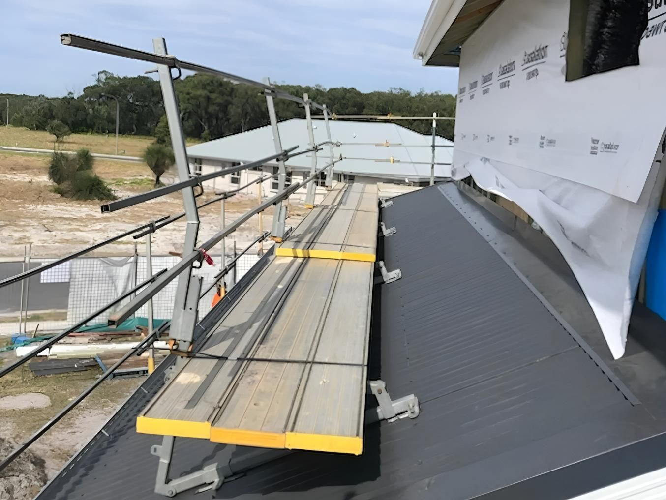 A Wooden Scaffolding Is Sitting on Top of A Building Under Construction — Site Safety NSW in Mid North Coast, NSW