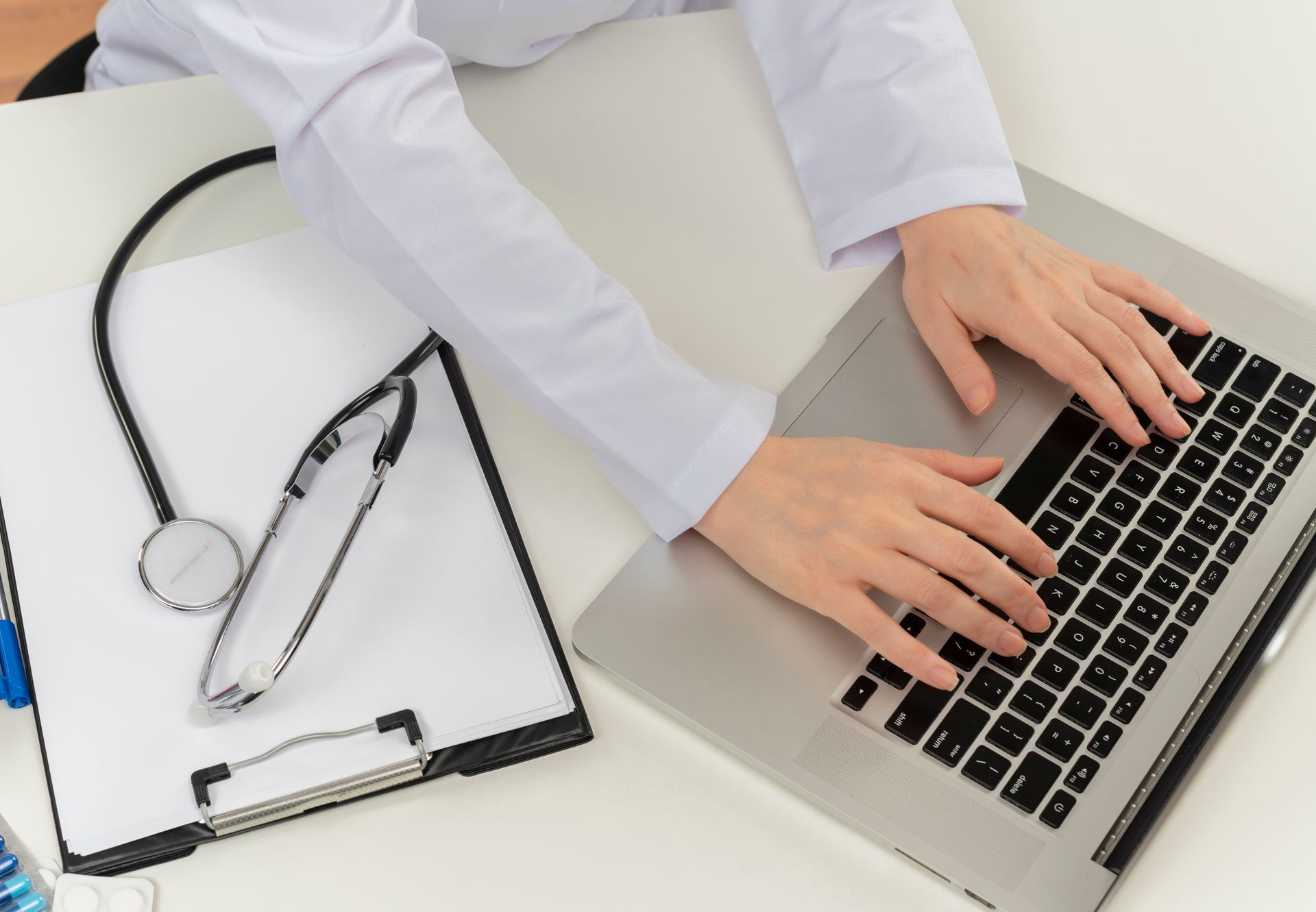 A clinician types patient information into an electronic prescription system to improve speed and accuracy in their pharmacy workflow.