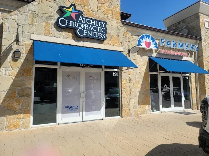 Storefronts for Atchley Chiropractic Centers and Farmers, with blue awnings in a strip mall
