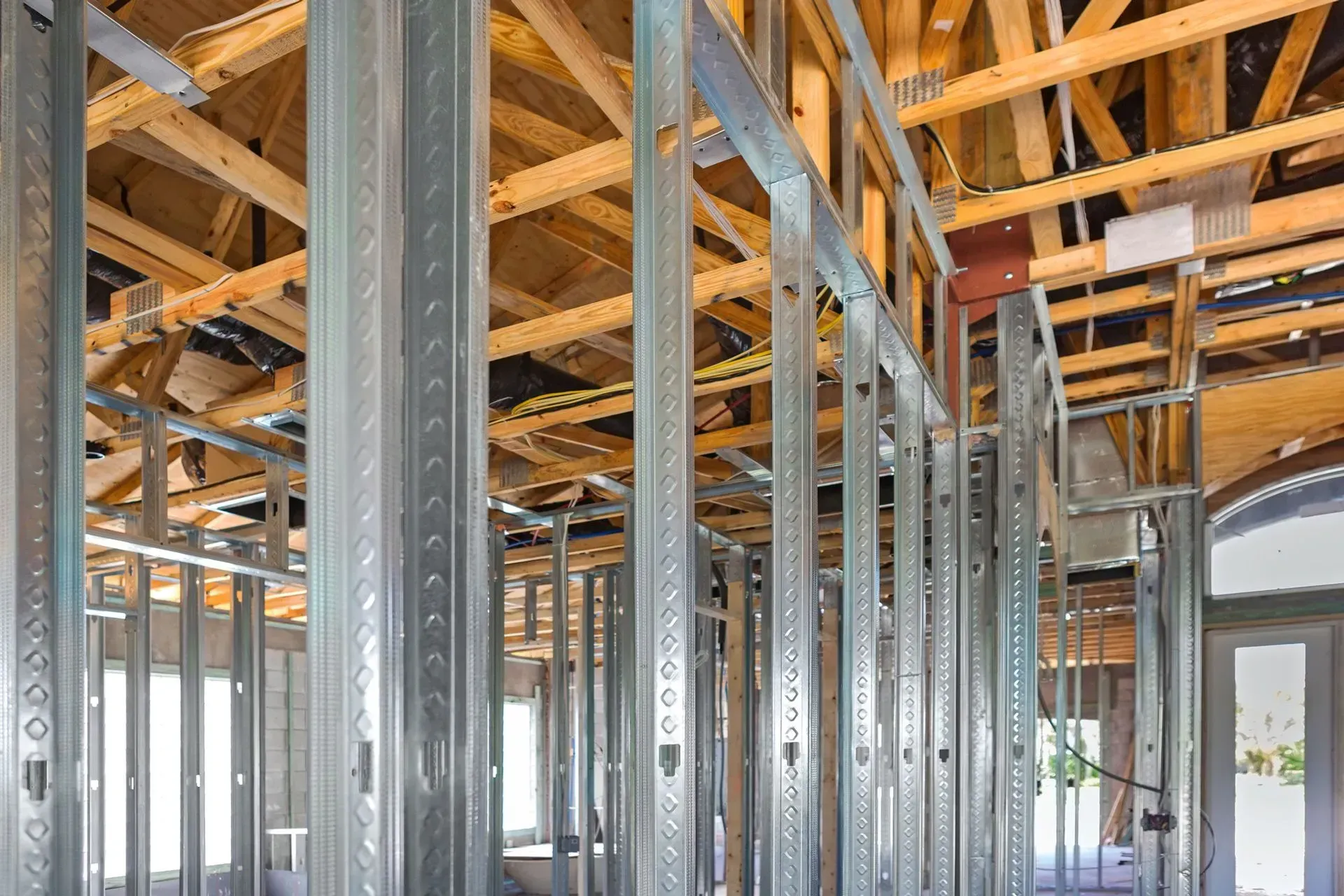 Metal framing and exposed wooden beams inside a building under renovation during foundation work.