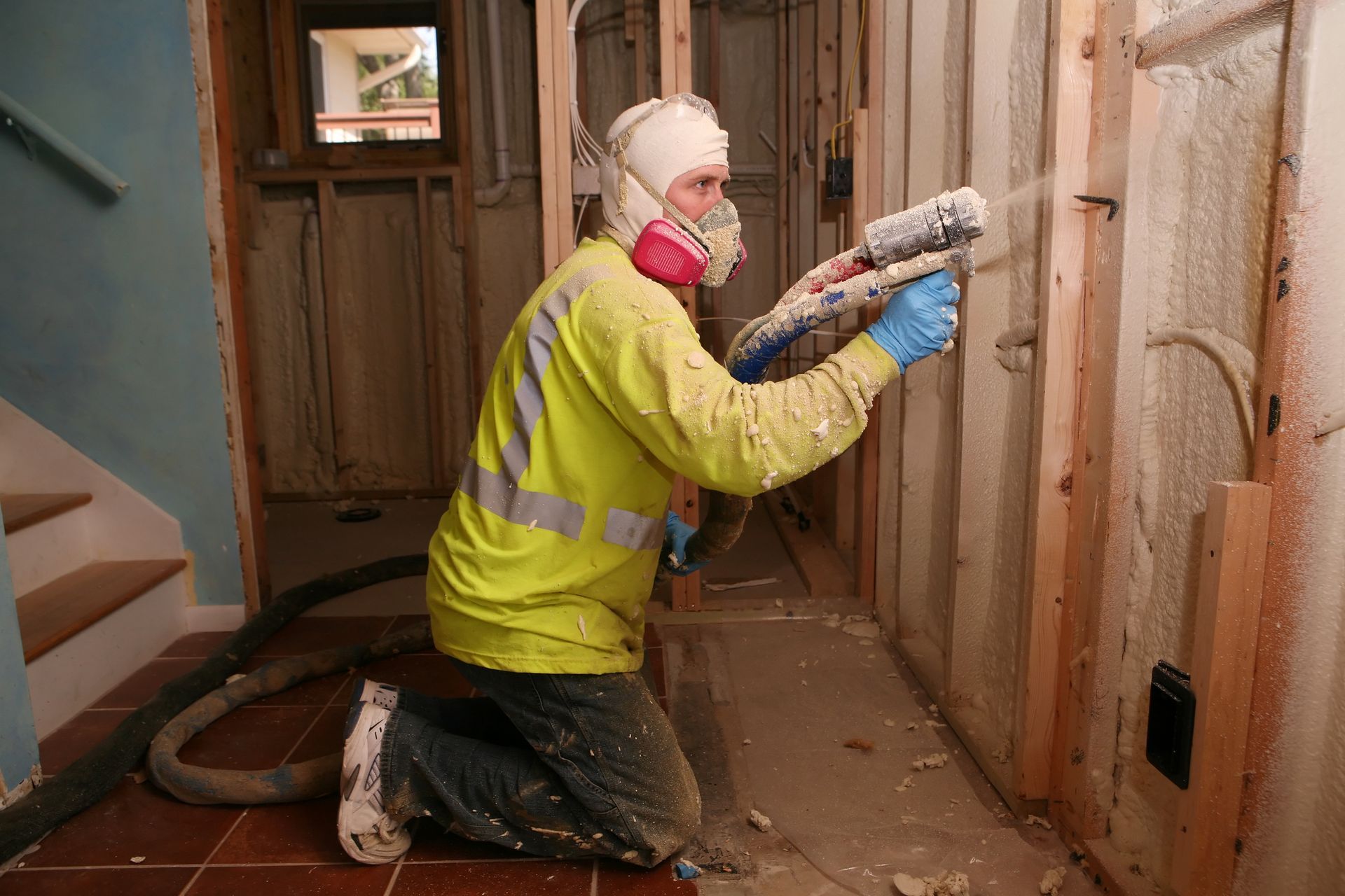 Person drilling concrete with a pneumatic hammer, spraying dust.