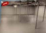 Gray, empty room with metal support beams and a concrete floor, possibly a basement after renovation.