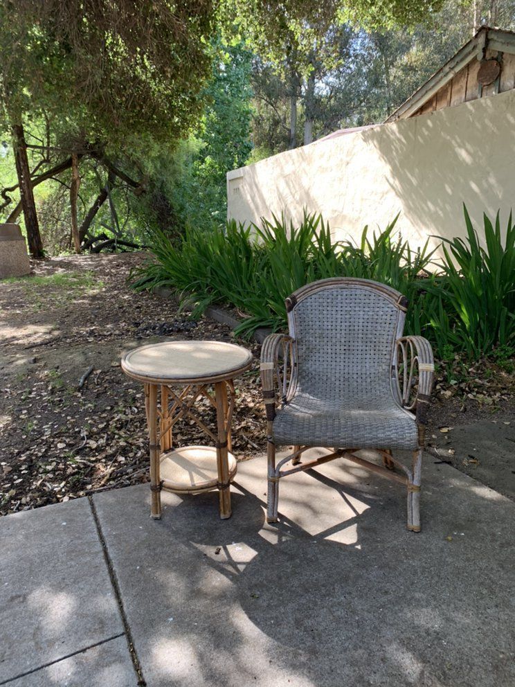 A chair and a table are sitting on a patio.