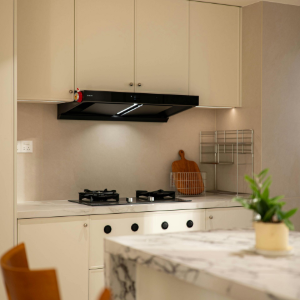 Modern kitchen with white cabinets, marble island, black range hood, and two wooden chairs