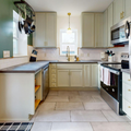 Bright modern kitchen with stainless steel appliances, light cabinets, and a small island.