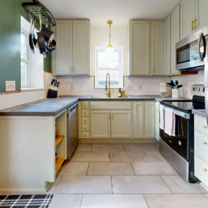 Bright modern kitchen with stainless steel appliances, light cabinets, and a small island.