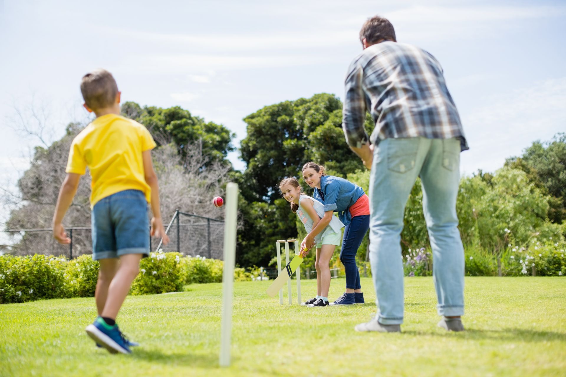 Family playing cricket outdoors Family playing cricket outdoors