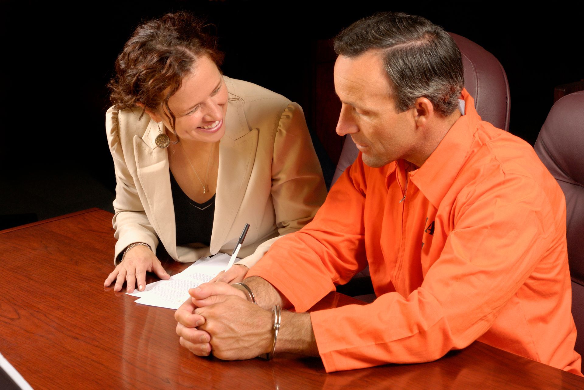 A lawyer is congratulating a client for securing bail bonds and achieving their release from jail. A lawyer is congratulating a client for securing bail bonds and achieving their release from jail.